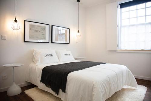 a white bedroom with a large bed with two pillows at Cristal apartamento 1 esq Monte Brasil in Angra do Heroísmo