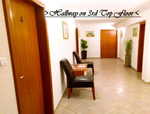 a hallway with two chairs and a table in a room at House White Stone Split in Podstrana