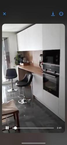 - une cuisine avec 2 chaises, un comptoir et une cuisinière dans l'établissement Endroit calme, à Nice