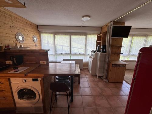 a kitchen with a table and a washer and dryer at Studio station Puy-Saint-Vincent in Puy-Saint-Vincent