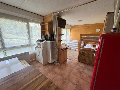 a kitchen with a small refrigerator and a bed at Studio station Puy-Saint-Vincent in Puy-Saint-Vincent