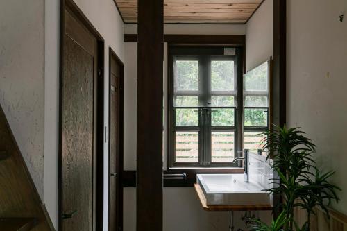 a bathroom with a sink and a window at Villa Classico Itoshima in Itoshima