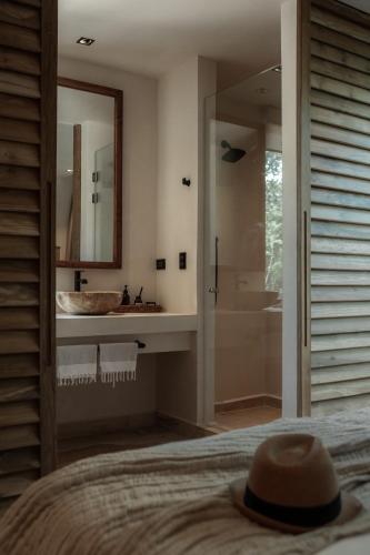 a bedroom with a bathroom with a sink and a mirror at Ka'ana Condo in Tulum