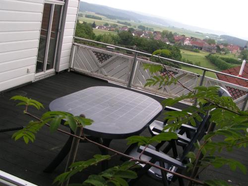 a table and chairs on a balcony with a view at Wellness und Wander Oase Burgwald 