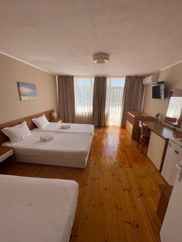a hotel room with two beds and a kitchen at Къща за гости Смокиня in Obzor