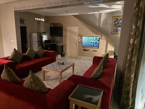 a living room with two red couches and a table at فلل الخالدية in Jeddah