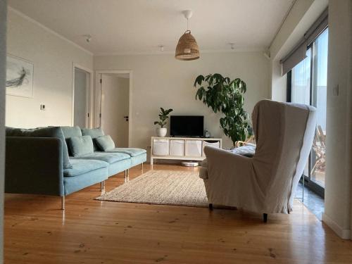 a living room with a couch and chairs and a tv at Casa Sol e Mar - Family stays in Torres Vedras