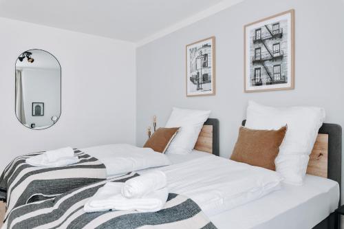a bedroom with two beds and a mirror at NEU Zweiraumstil I Modernes Design I voll ausgestattet I Sehr ruhige Lage I Arbeitsplatz I Hotelbetten I Smart TV mit Netflix und Magenta I Frisch saniert in Bad Bevensen