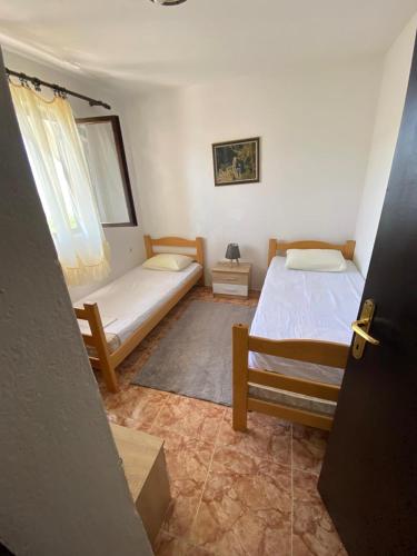 a bedroom with two beds and a window at Bigova Peace Oasis in Bigova