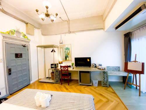 a room with a bed and a desk with a computer at Yuu Hotel Ubon Ratchathani in Ubon Ratchathani