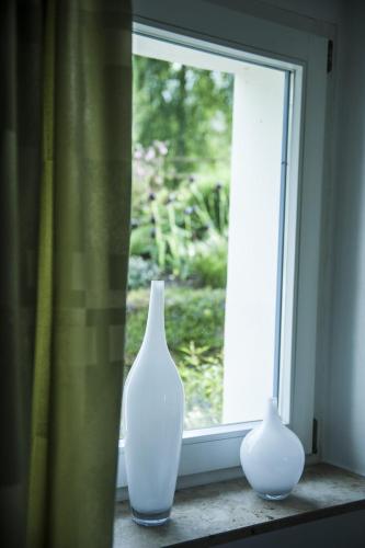 two white vases sitting on a window sill at Wohlfühloase Für Natur Und Gartenliebhaber in Walkenried
