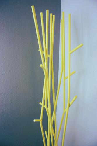 a vase filled with bamboo sticks next to a wall at Wohlfühloase Für Natur Und Gartenliebhaber in Walkenried