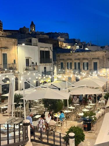 a group of people sitting at tables under umbrellas at La casa di Laura in Ostuni