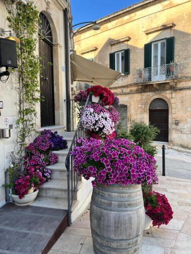 a barrel filled with lots of purple and red flowers at La casa di Laura in Ostuni