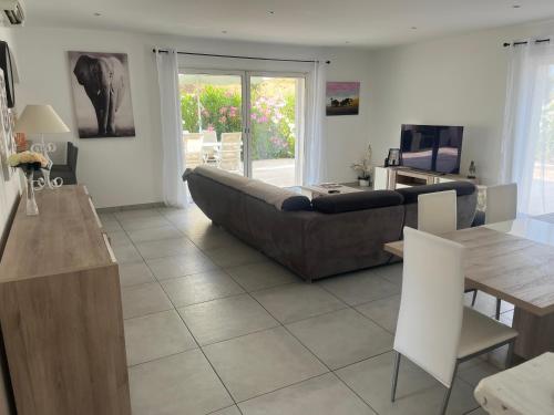 un salon avec un canapé et une table dans l'établissement Les Néfliers, à Sainte-Maxime