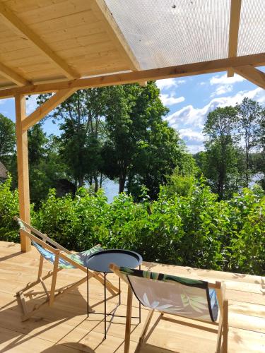 Dos sillas y una mesa en una terraza. en Domek z widokiem na jezioro, en Jora Wielka