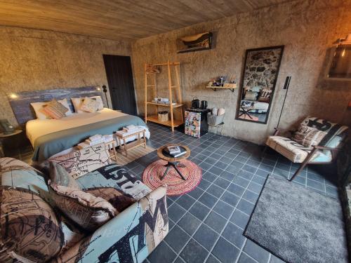 a bedroom with a bed and a couch at Solar dos limas in Criação Velha
