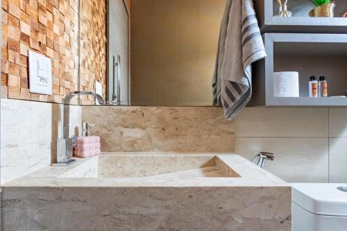 a bathroom with a large marble sink in a room at Apartamento - 5min do Aeroporto - Vila Telebrasília in Brasilia