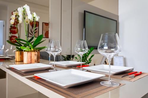 a table with wine glasses and plates on it at Apartamento - 5min do Aeroporto - Vila Telebrasília in Brasilia
