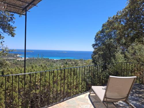 a patio with a chair and a view of the ocean at Résidence Belvedere de Palombaggia in Porto-Vecchio