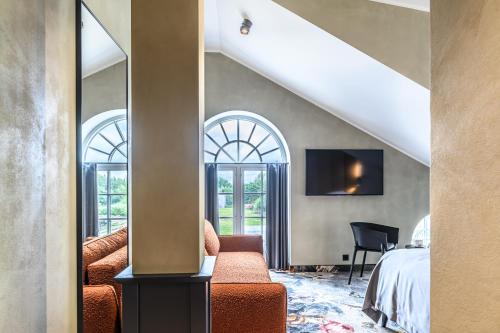 a living room with a couch and a bed and windows at Hotell Moe 