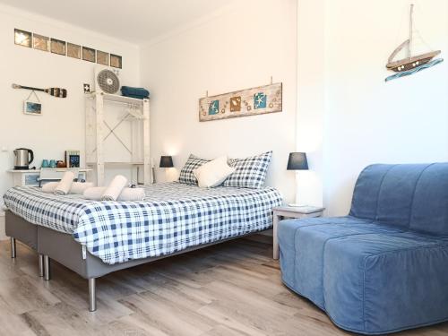 a bedroom with a bed and a blue couch at Onda Vicentina Guesthouse in Aljezur