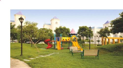 a park with benches and a playground in front of a building at Casa Royale An Escape with Elegance in Amritsar
