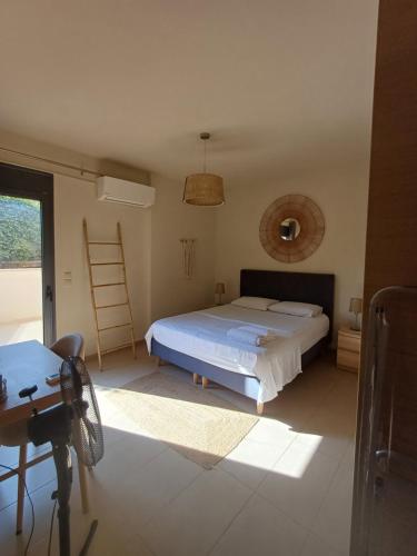 a bedroom with a bed and a desk and a window at Pool apartment 5 minutes walk from beach in Porto Rafti