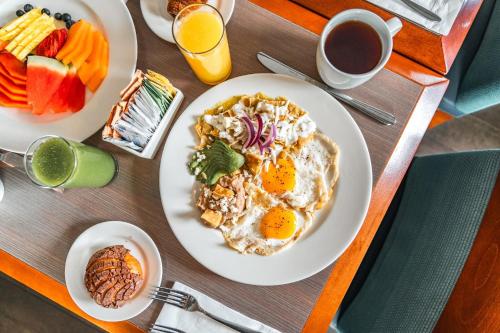 a table with two plates of breakfast foods and coffee at Holiday Inn Guadalajara Patria-Universidad by IHG in Guadalajara