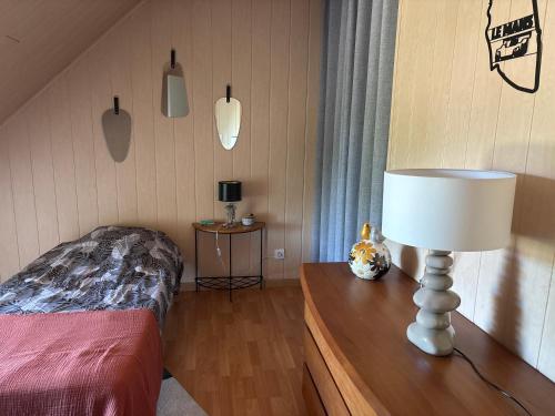 a bedroom with a bed and a lamp on a table at Chambre proche circuit in Spay