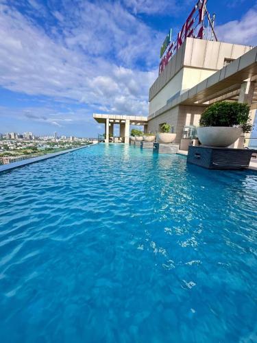a pool on the roof of a building with blue water at LuxePink Teddd Jucuzzi Studio-PrivatePatio in Gurgaon