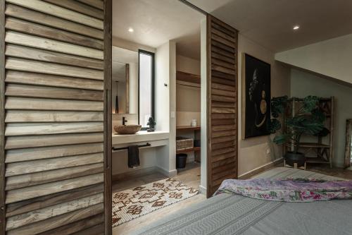 a bathroom with a wooden wall with a sink and a mirror at Ka'ana Condo in Tulum