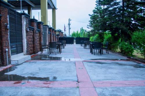 a patio with tables and chairs next to a building at Zoey International Hotels Ltd in Owerri