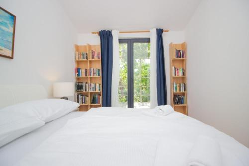 a bedroom with a bed and a window with bookshelves at Villa Mediteran - Beach Villa with Jacuzzi in Vir