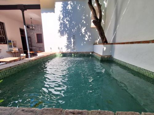 einem Pool mit grünem Wasser in einem Gebäude in der Unterkunft Hotel Casa de los Azulejos in Córdoba