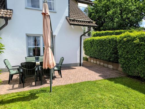 a patio with a table and an umbrella at Tor zum Saueland mit Sauna und Whirlpool in Olpe