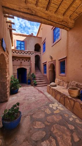 a courtyard of a building with stairs and potted plants at Dar Mouna in Aït Ben Haddou