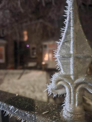 a close up of a metal fence with snow on it at Fendoch Guest House in Inverness