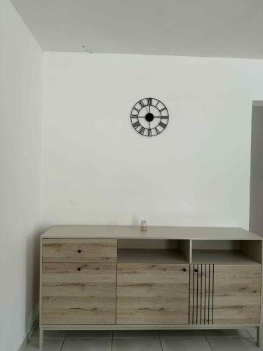 a desk with a clock on a white wall at Expédit Horizon in Salazie