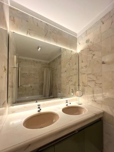 a bathroom with two sinks and a large mirror at inluz apartment in Vila do Conde