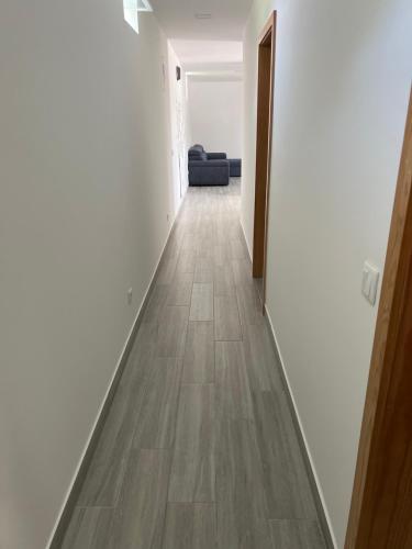 a hallway with white walls and a wooden floor at Casa bernardino in Esmoriz