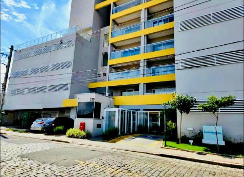 a large building with a parking lot in front of it at Studio 114 Luxury Mogi Das Cruzes in Mogi das Cruzes