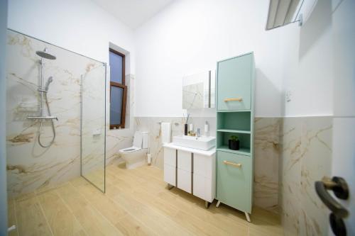 a bathroom with a shower and a sink and a toilet at H&H Luxury Apartments in Arad