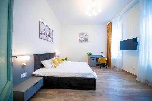 a small bedroom with a bed and a desk at H&H Luxury Apartments in Arad