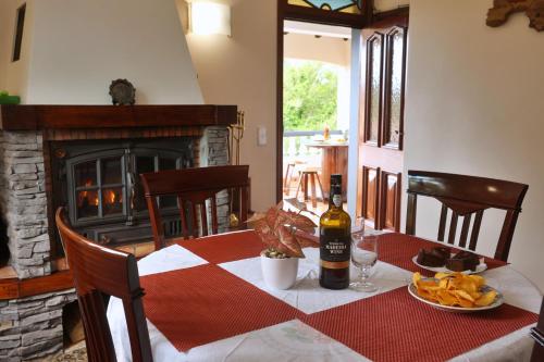 un tavolo con una bottiglia di vino e un piatto di cibo di Casa da Cascata a Santana
