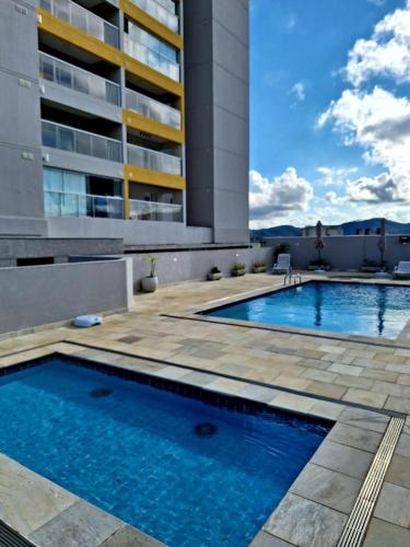 a swimming pool in front of a building at Studio 114 Luxury Mogi Das Cruzes in Mogi das Cruzes