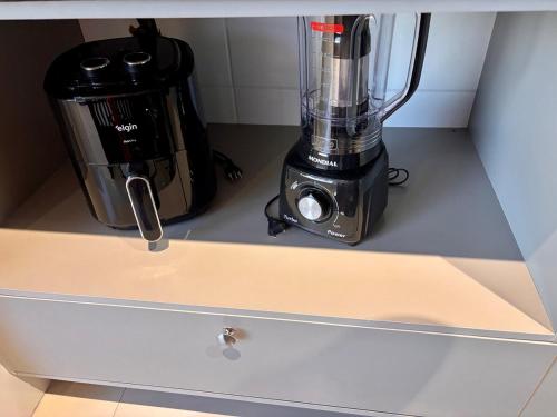 a blender sitting on a counter next to a coffee maker at Studio 114 Luxury Mogi Das Cruzes in Mogi das Cruzes