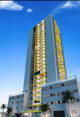 a tall building with palm trees in front of it at Studio 114 Luxury Mogi Das Cruzes in Mogi das Cruzes