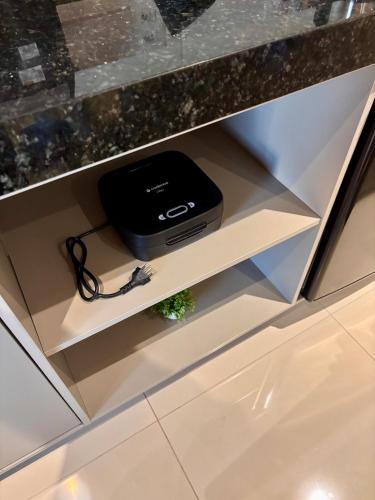 a drawer with a black appliance in a cabinet at Studio 114 Luxury Mogi Das Cruzes in Mogi das Cruzes