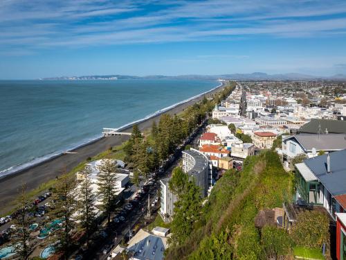 an aerial view of a city and the ocean at Cape View - Napier Holiday Home in Napier